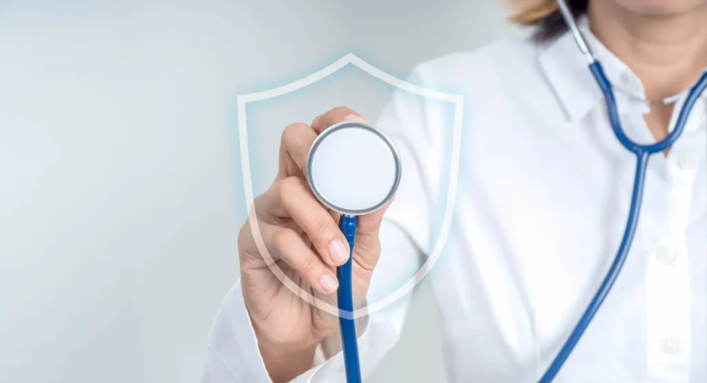 Doctor holding a stethoscope with a protective shield graphic, representing free preventive services in your plan and proactive healthcare coverage.