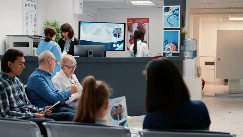 Patients sitting in a hospital waiting room, illustrating what to expect when visiting the emergency room without insurance and navigating uninsured ER care.