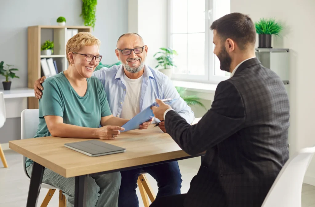 A retired couple meeting with an advisor to review COBRA vs. retiree health insurance options