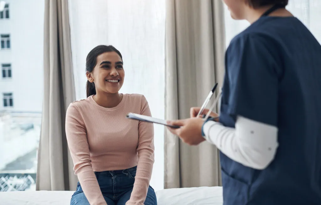 Health insurance after turning 26 consultation with nurse and patient reviewing tablet